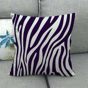 Close-up of square linen pillow cover with purple zebra stripes on a gray sofa