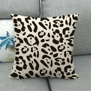 Macro detail of natural linen pillowcase texture featuring black leopard pattern on a sofa