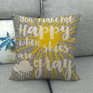 Linen sun and cloud pillow cover with You Make Me Happy quote on gray sofa