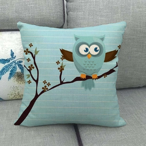 Close-up of a cartoon owl linen pillowcase on a grey sofa with light blue stripes