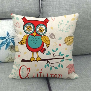 Linen cushion cover with owl illustration and Autumn text on grey fabric sofa