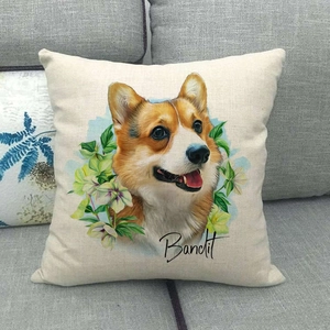 Kissenbezug aus Leinen mit Corgi-Porträt und Blumendetails auf einem grauen Sofa