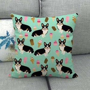 Detail eines Kissenbezugs aus Leinen mit Corgi- und Eismuster auf grauem Sofa
