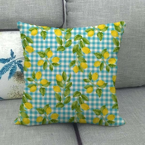 Close-up of linen cushion cover with lemon pattern on blue and white checkered background