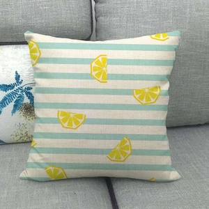 Close-up of linen cushion cover featuring green stripes and bright yellow lemon patterns