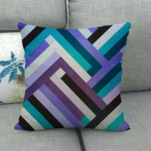 Abstract geometric linen pillowcase with blue and purple patterns on grey sofa