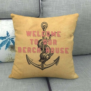 Detail of linen pillow cover with black anchor and Welcome To Our Beach House text