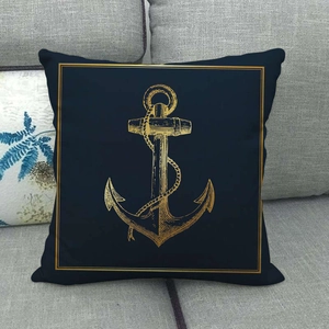 Close-up of vintage anchor linen pillowcase on a sofa with detailed gold nautical print