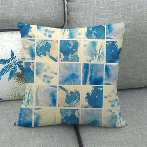 Linen decorative pillowcase featuring blue watercolor geometric patterns on a grey sofa