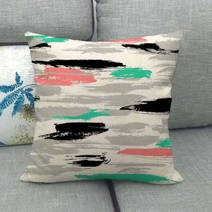 Linen throw pillow case with abstract geometric patterns on a grey sofa background