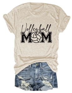 Flat lay of a beige volleyball mom t-shirt paired with distressed blue denim shorts