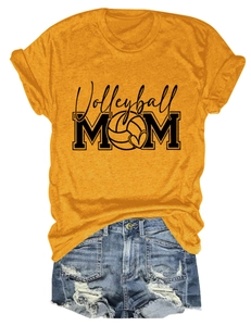 Flat lay of a mustard yellow Volleyball MOM t-shirt with distressed denim shorts