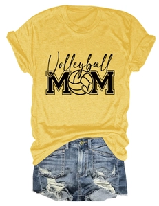 Flat lay of ginger yellow Volleyball Mom t-shirt with denim shorts on white backdrop