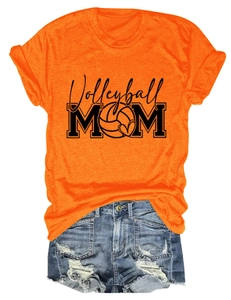 Flat lay of an orange Volleyball MOM t-shirt paired with ripped denim shorts