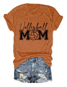 Detailed flat lay of bright orange Volleyball Mom t-shirt and distressed denim shorts