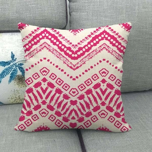 Détail de motifs géométriques roses sur une housse de coussin en lin texturé sur canapé
