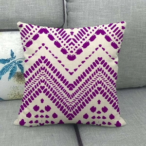 Détails des motifs tribaux violets sur une housse de coussin carrée en lin texturé