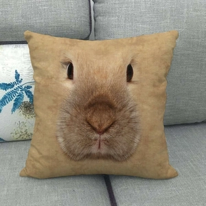 Linen pillow cover with realistic rabbit face print on grey fabric sofa