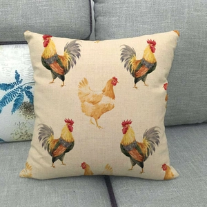Gros plan sur la housse de coussin en lin avec motif de coq sur un canapé gris