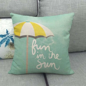 Close-up of linen cushion cover featuring mint green fabric and sun umbrella pattern