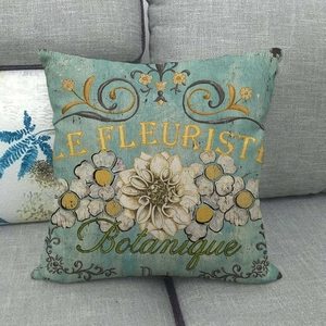 Detail of vintage blue linen pillow cover featuring botanical Le Fleuriste art on a gray sofa
