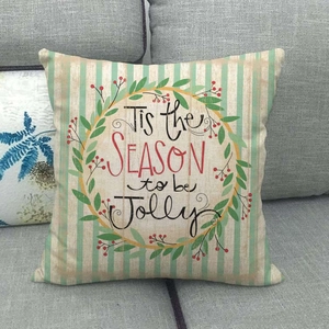 Detail of linen texture and festive 'Tis the Season to be Jolly' lettering on Christmas pillow