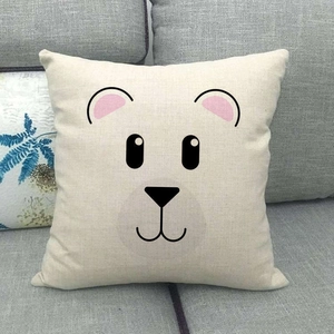 Dettaglio del motivo a orsetto minimalista su un copricuscino in lino beige naturale