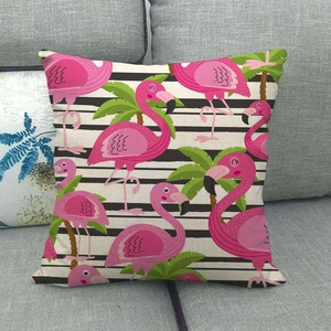 Linen flamingo pillow cover with tropical palm leaves and black stripes on a grey sofa