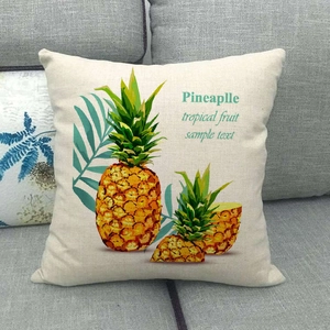 Detail of a beige cotton linen cushion cover with a tropical pineapple print on a sofa
