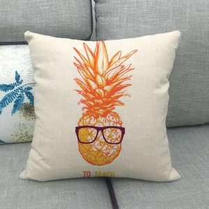 Detail of square linen pillow featuring a creative pineapple with glasses and beach text