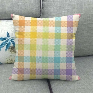 Square rainbow striped linen pillowcase on a grey fabric sofa with a colorful woven texture
