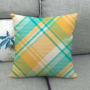 Close-up of yellow and green plaid linen pillowcase texture on a grey sofa
