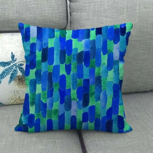 Close-up of geometric linen-style pillowcase with blue and green mosaic patterns