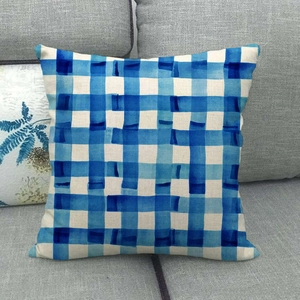 Close-up of blue and white watercolor checkered linen throw pillow on a grey sofa