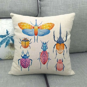 Détail de la housse de coussin en lin montrant la texture et les motifs d'insectes