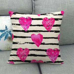 Close-up of linen pillowcase with black horizontal stripes and pink watercolor hearts