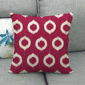 Close-up of geometric white tie-dye ring pattern on a red linen throw pillow cover