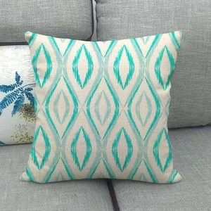 Macro detail of geometric teal ikat diamond pattern on textured linen cushion cover