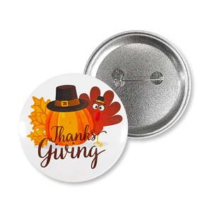 Close-up of Thanksgiving tinplate badges showing festive pumpkin design and metal pin back