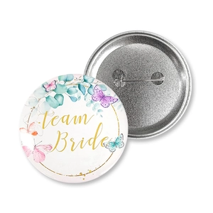 Detail of Team Bride tinplate badge with floral butterflies and safety pin back