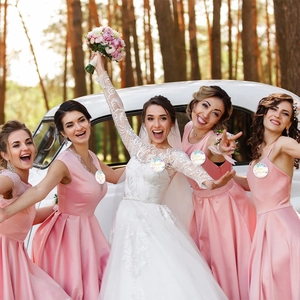 Group of bridesmaids holding floral Team Bride and Bride to Be badges at a wedding party