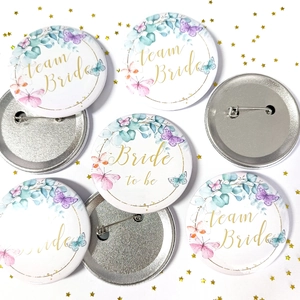 Front and back details of Team Bride tinplate badge with floral wreath and safety pin