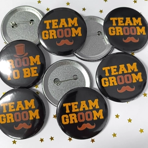 Macro detail of Team Groom and Groom To Be tinplate badges with pins for bachelor parties