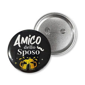 Macro view of tinplate groomsman badge with Amico dello Sposo text and pin back detail
