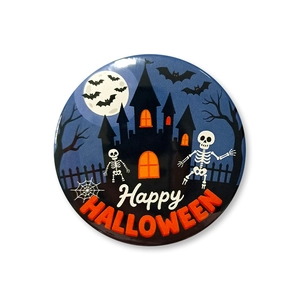 Macro shot of 58mm Halloween badge with skull and castle design on white background