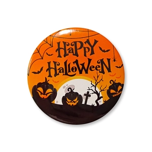 Close-up of Halloween tinplate badge featuring pumpkins, bats and Happy Halloween text