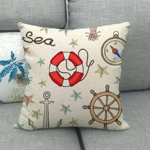 Close-up of nautical linen pillowcase with anchor and sea motifs on a grey sofa