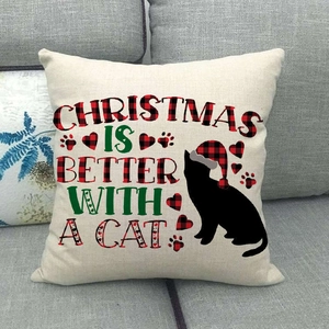 Housse de coussin Noël chat noir et bonnet à carreaux rouges sur canapé gris