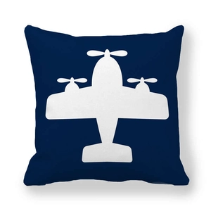 Detalle de la funda de cojín azul marino con silueta de avión de hélice en blanco