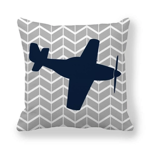 Detalle de funda de cojín con silueta de avión azul marino sobre tejido de espiga